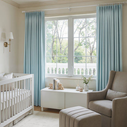 Light blue custom pleated blackout curtains in a nursery.