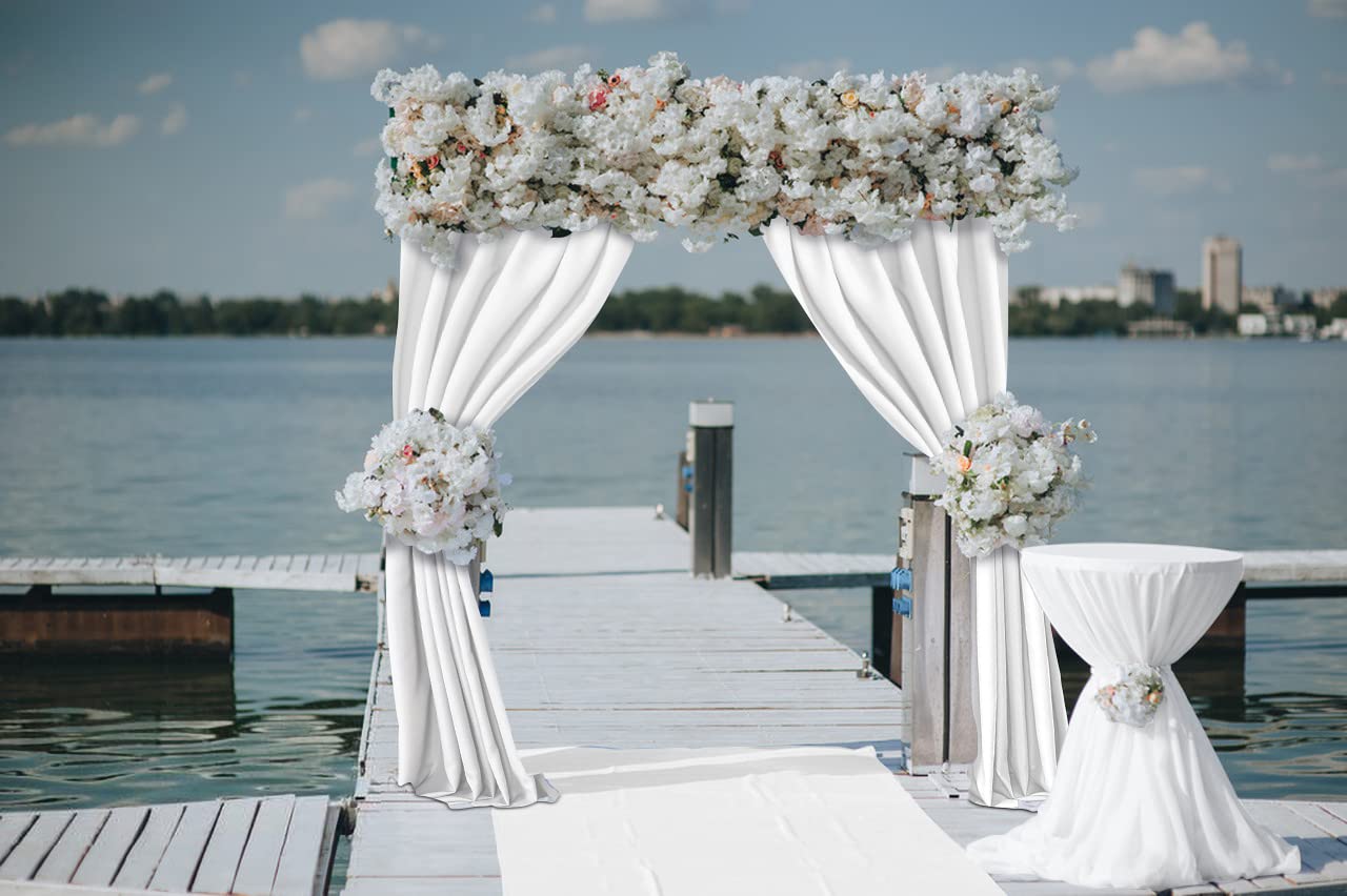 White polyester wedding backdrop curtains draped over arch with floral arrangements for elegant event decor.