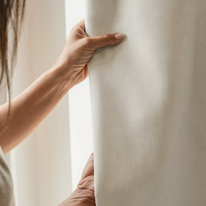 Everly heavyweight chenille blackout curtain: Hand touching luxurious fabric texture.