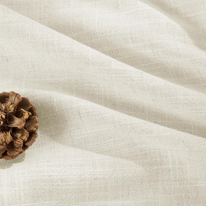 Close-up of ivory light-filtering linen curtains, textured weave, soft folds, with a pinecone accent.