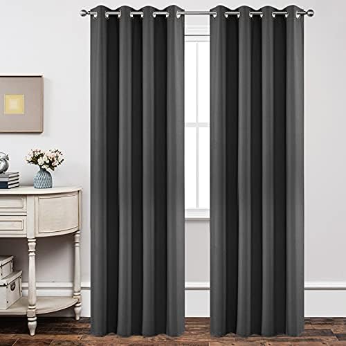 Two charcoal grey Joydeco blackout curtains 95 inch with grommets hang from a silver rod in a bedroom.