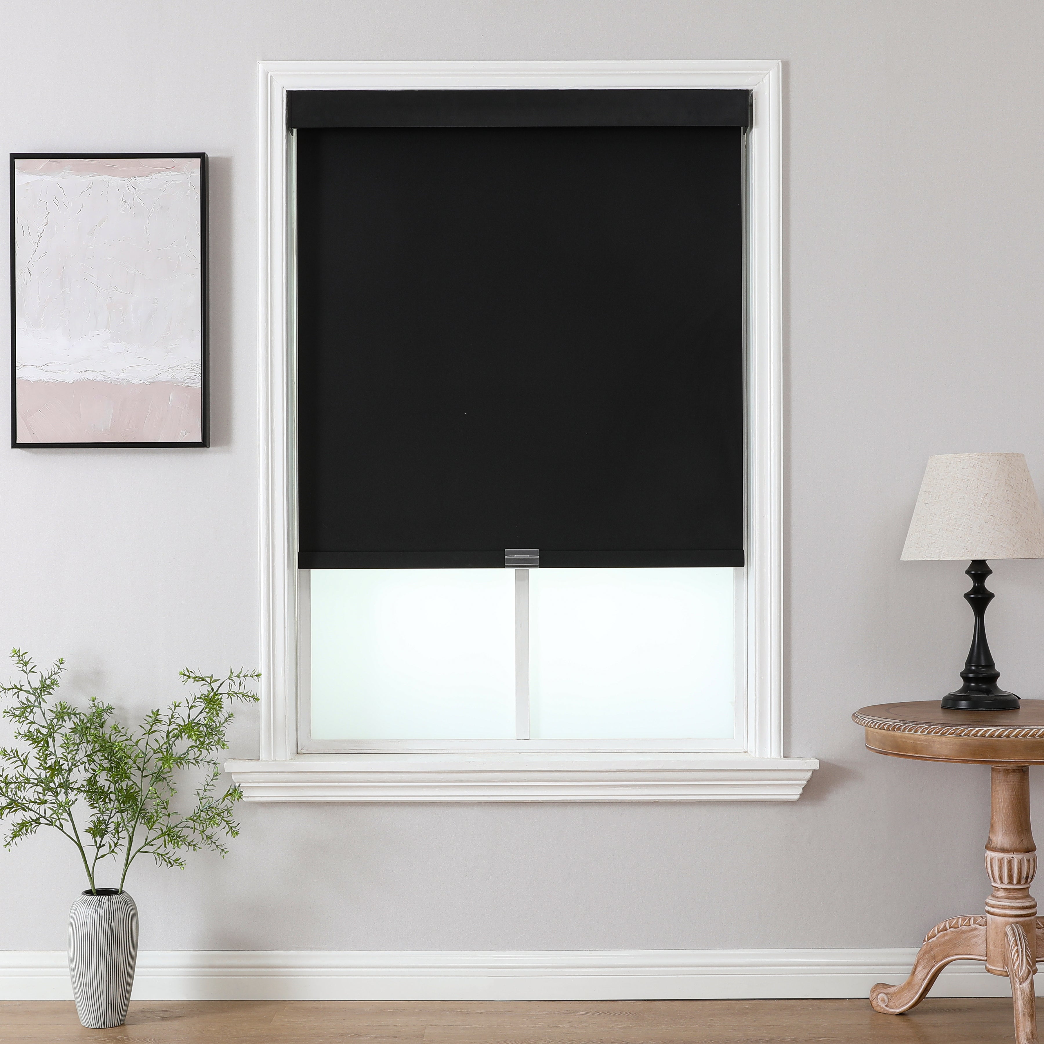 Black cordless blackout roller shade with aluminum valance installed on window for UV protection and home decor.