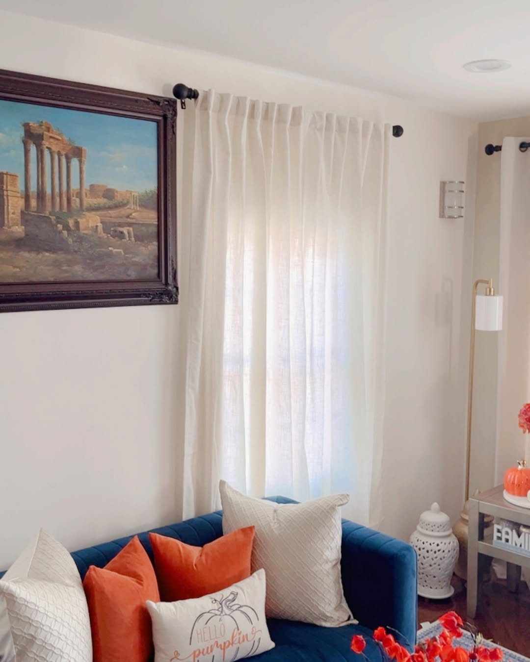 Joydeco semi-sheer off-white linen curtains in a living room, filtering light onto a blue sofa with decorative pillows.