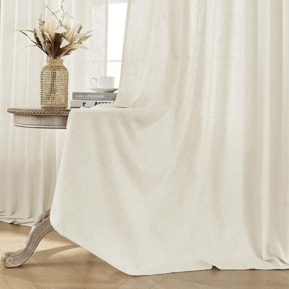 Joydeco ivory linen blend curtains gently filtering light in a living room setting with decorative vase and books on table.