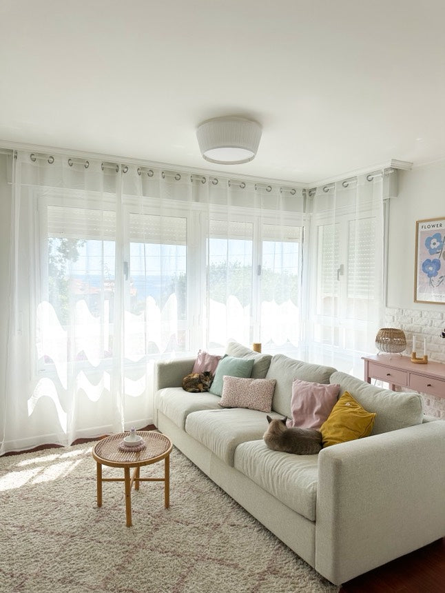 Joydeco white sheer curtains with rod pocket design in a living room, filtering sunlight onto a beige sofa with cats.