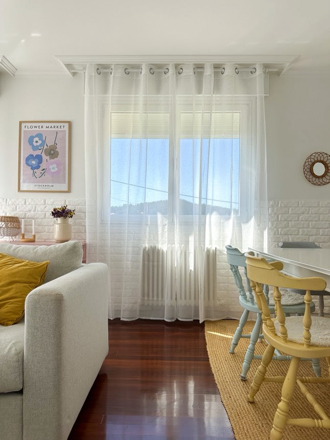 Joydeco white sheer curtains with dual rod pockets in a bright living room, filtering light onto a sofa and colorful chairs.
