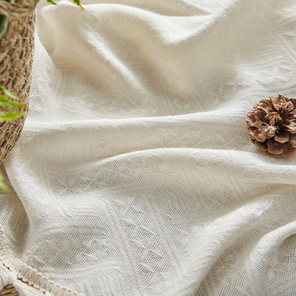 Close-up of cream boho curtain texture: basket weave, tassel trim, semi-sheer fabric for farmhouse style.