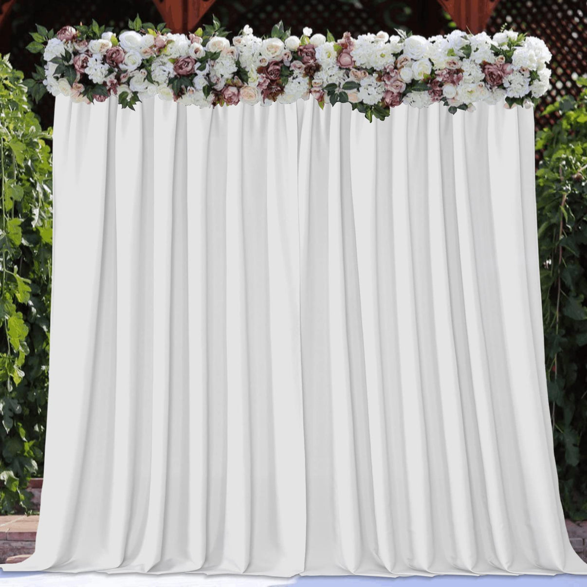 White polyester backdrop curtain with floral arrangement for wedding and party decor.