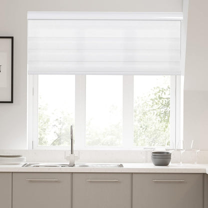 White Joydeco cordless zebra blinds semi-transparent over kitchen window with sink, offering light filtering and privacy.