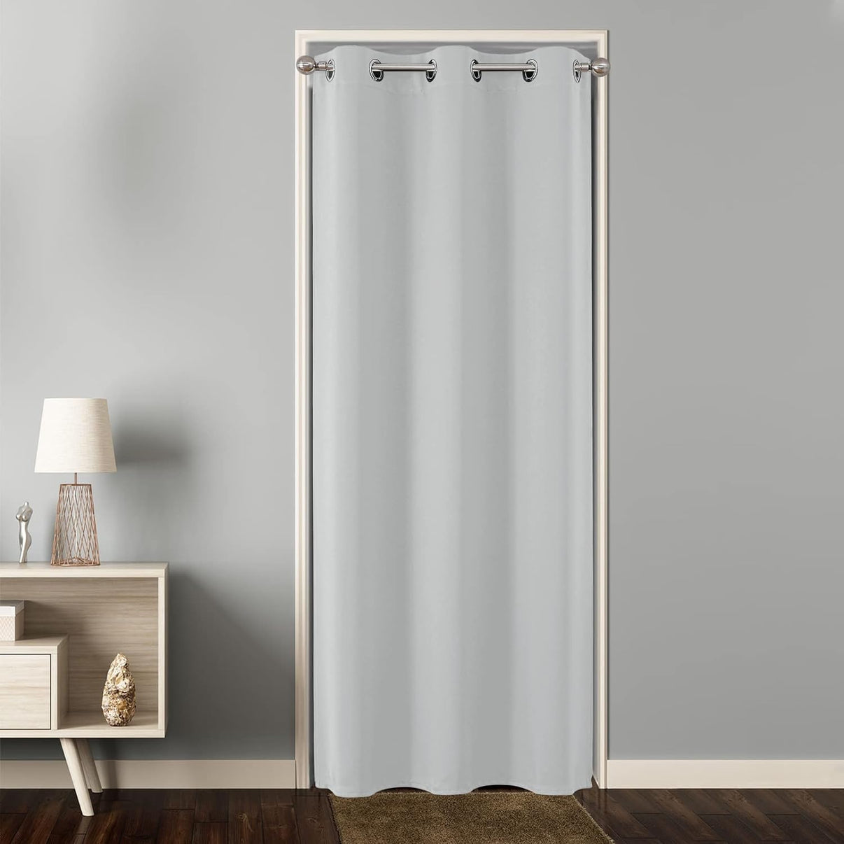 Light grey grommet blackout curtain used as a room divider on a doorway, floor-length, modern design.