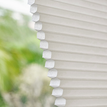 Joydeco Solace light filtering cellular shade in soft beige, showcasing honeycomb structure and textured polyester fabric.