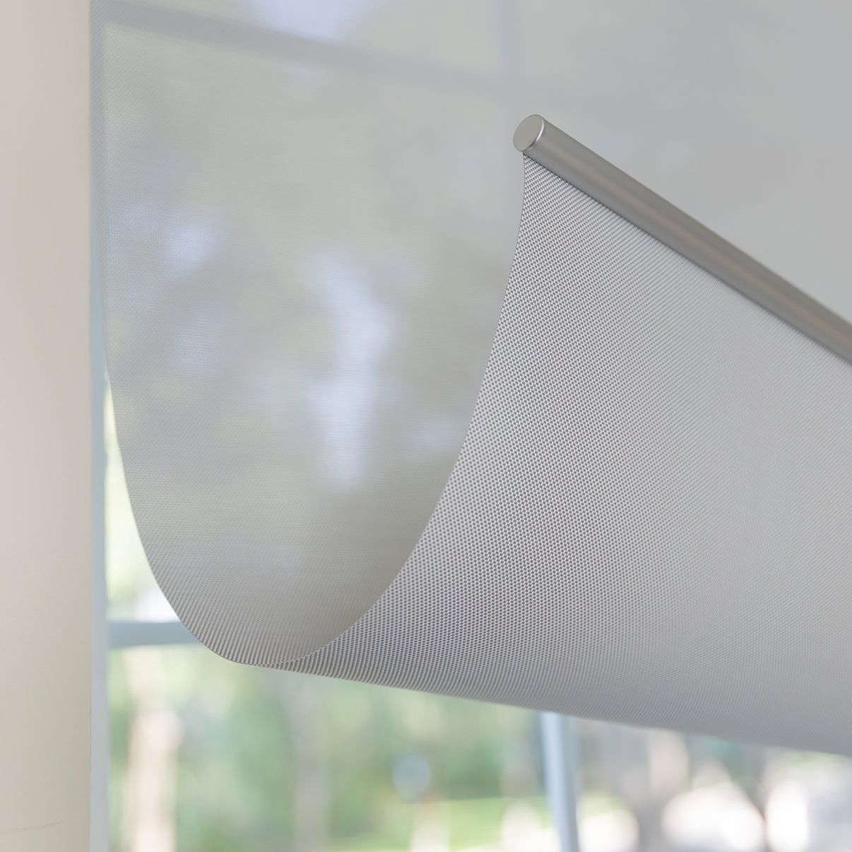 Joydeco Cove light filtering solar shade with semi-sheer grid fabric.