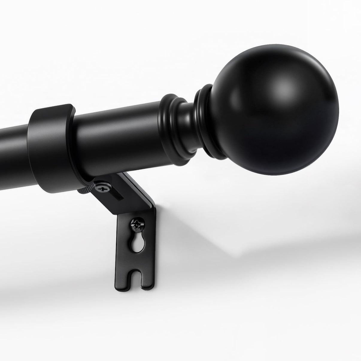 Joydeco matte black adjustable curtain rod, 1-inch diameter, with spherical finial, mounted on a white wall.