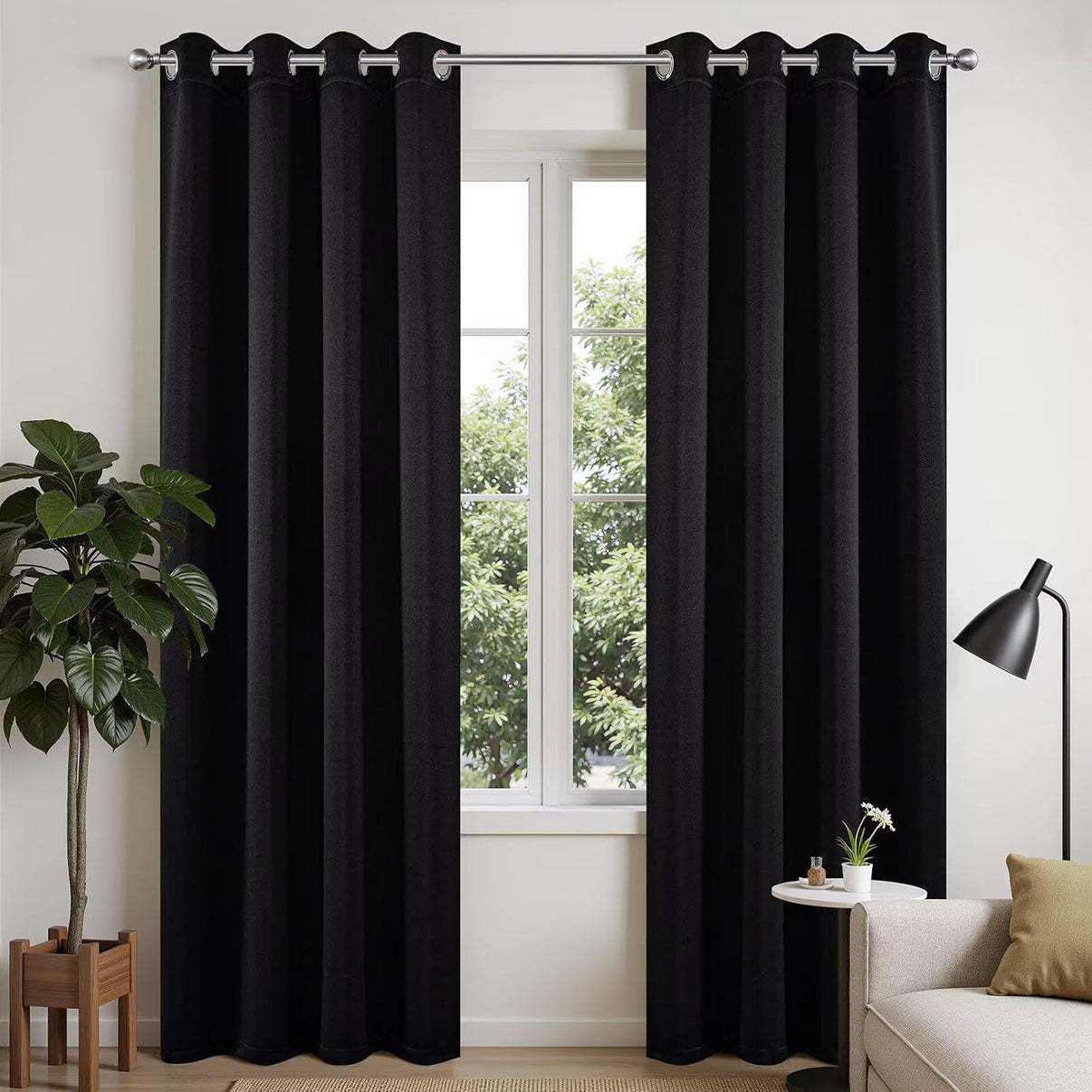 Joydeco black 108 inch blackout curtains with silver grommets, shown on a window with decor.