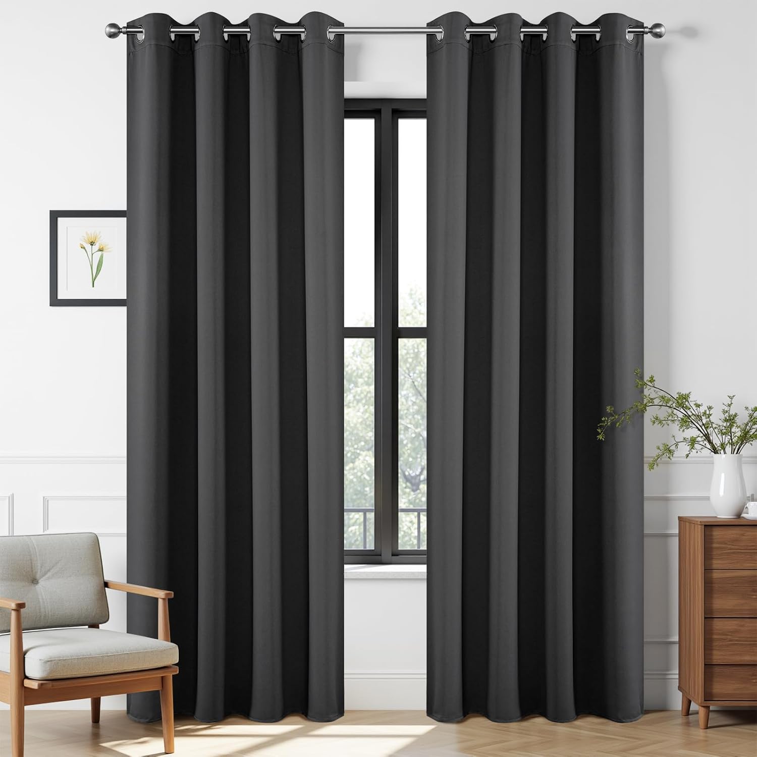 Two dark grey extra long blackout curtains with grommets on a rod in a living room setting.