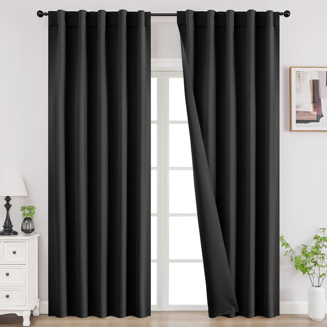 Joydeco 90 inch blackout curtains in black, two panels shown with back tab hanging on a rod in a room setting.