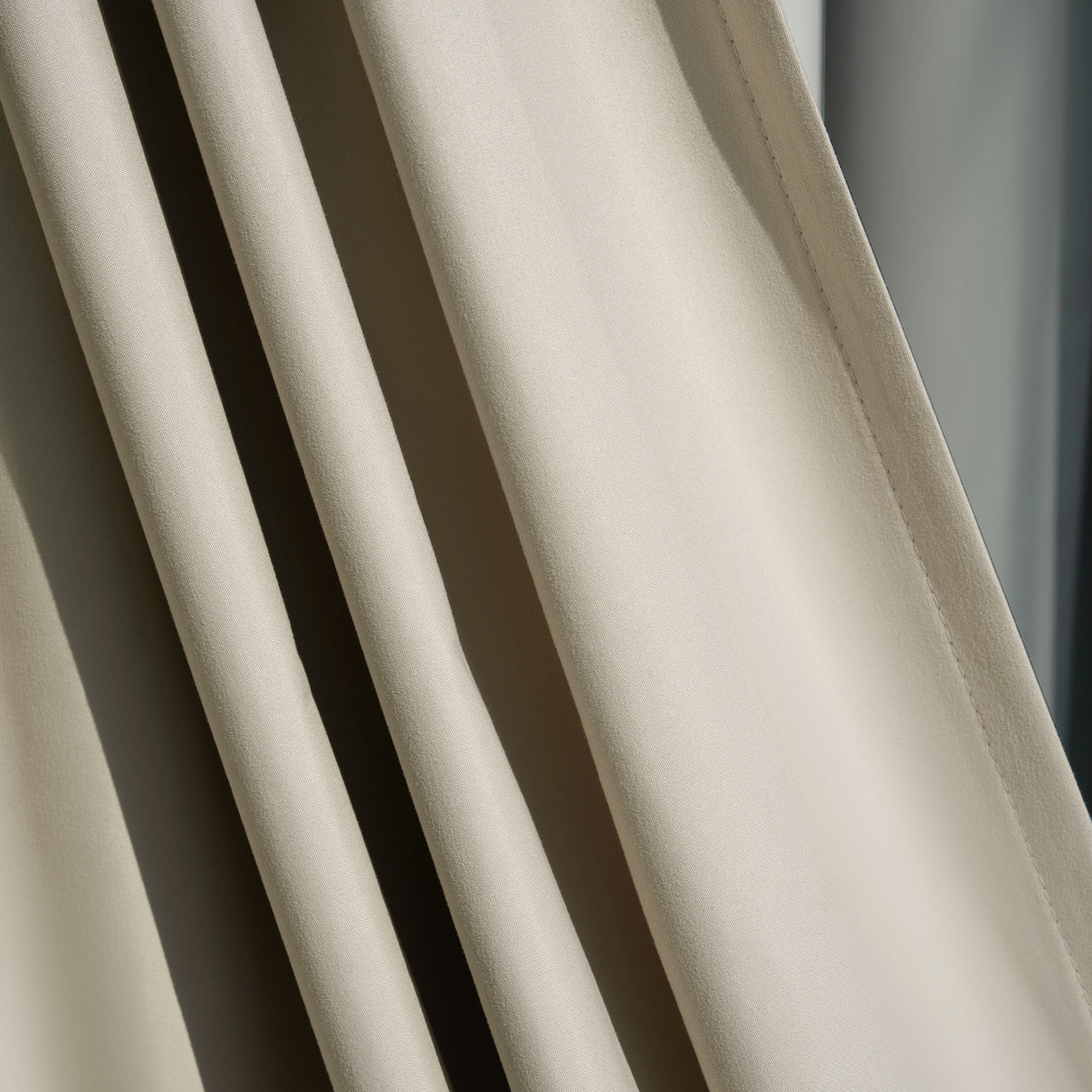 Arden satin blackout curtain fabric in light beige, smooth lustrous texture and elegant drape.