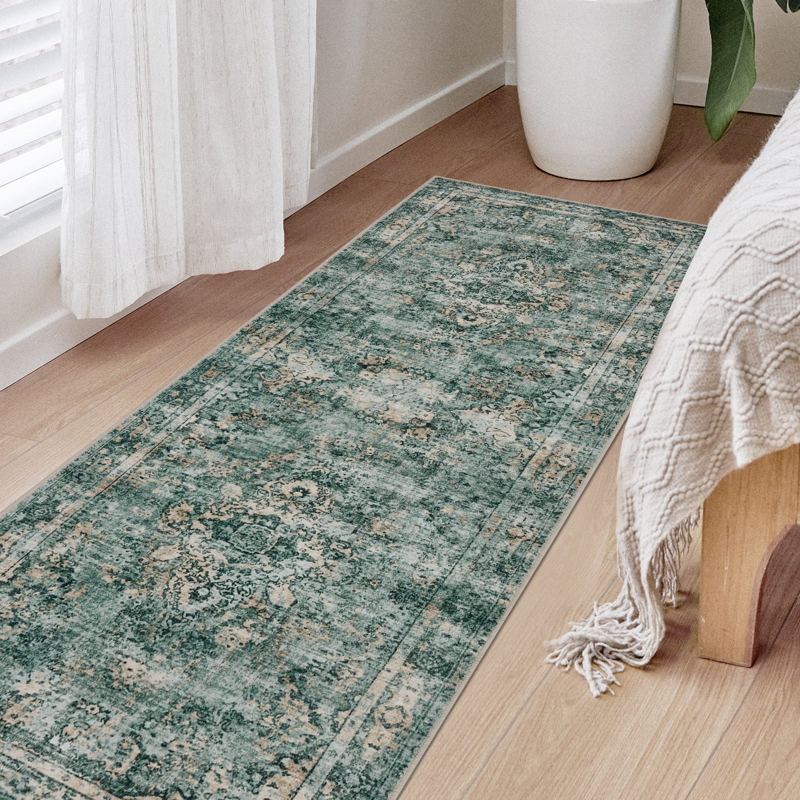 Joydeco teal distressed floral runner rug with low pile on light wood floor near bed and curtain.