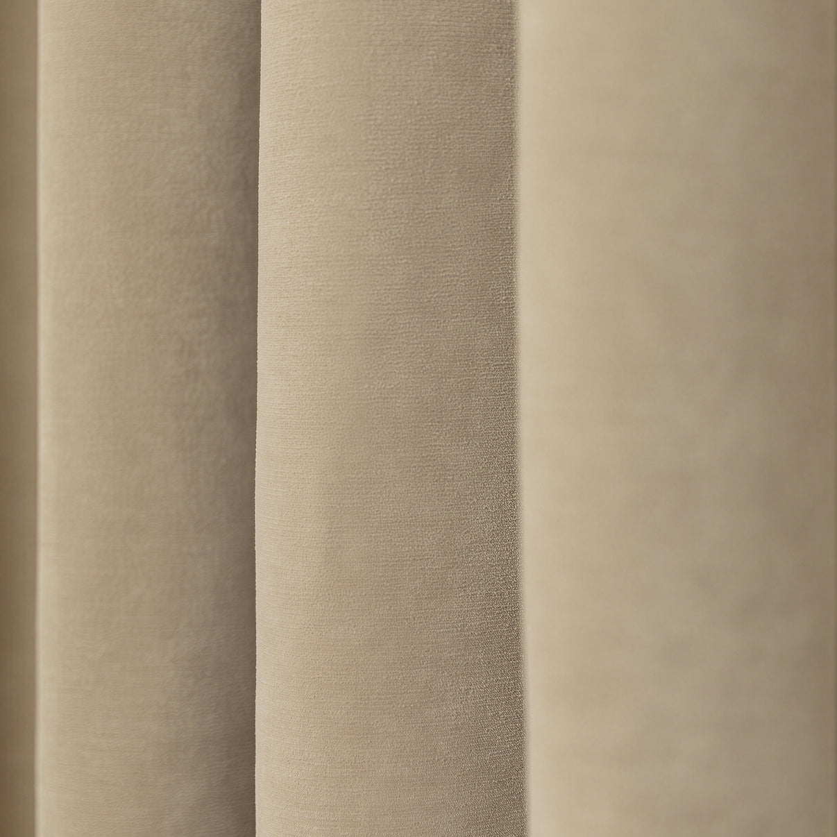Bennett Chenille blackout curtain in light beige, showing plush texture and elegant draped folds.