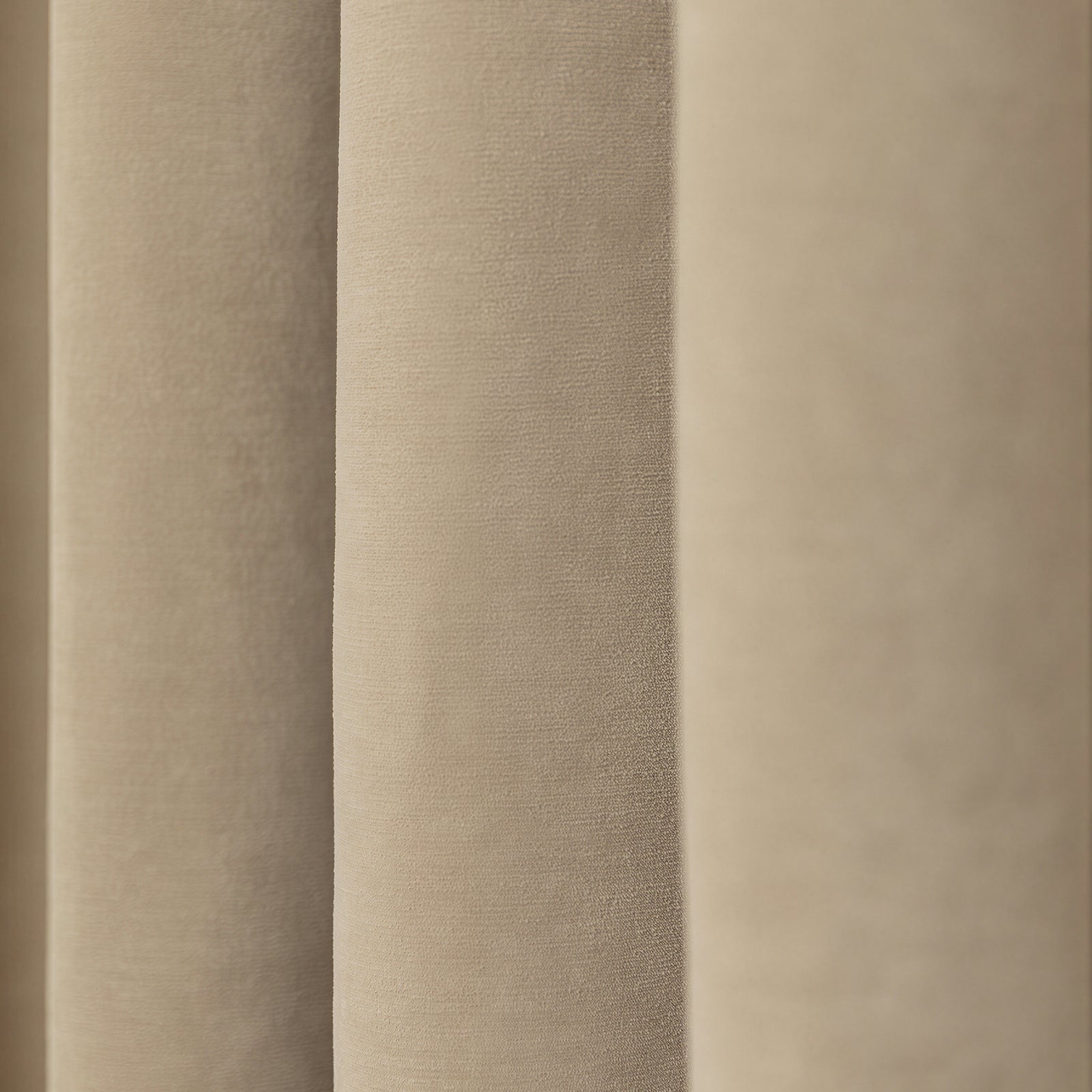 Bennett Chenille blackout curtain in light beige, showing plush texture and elegant draped folds.