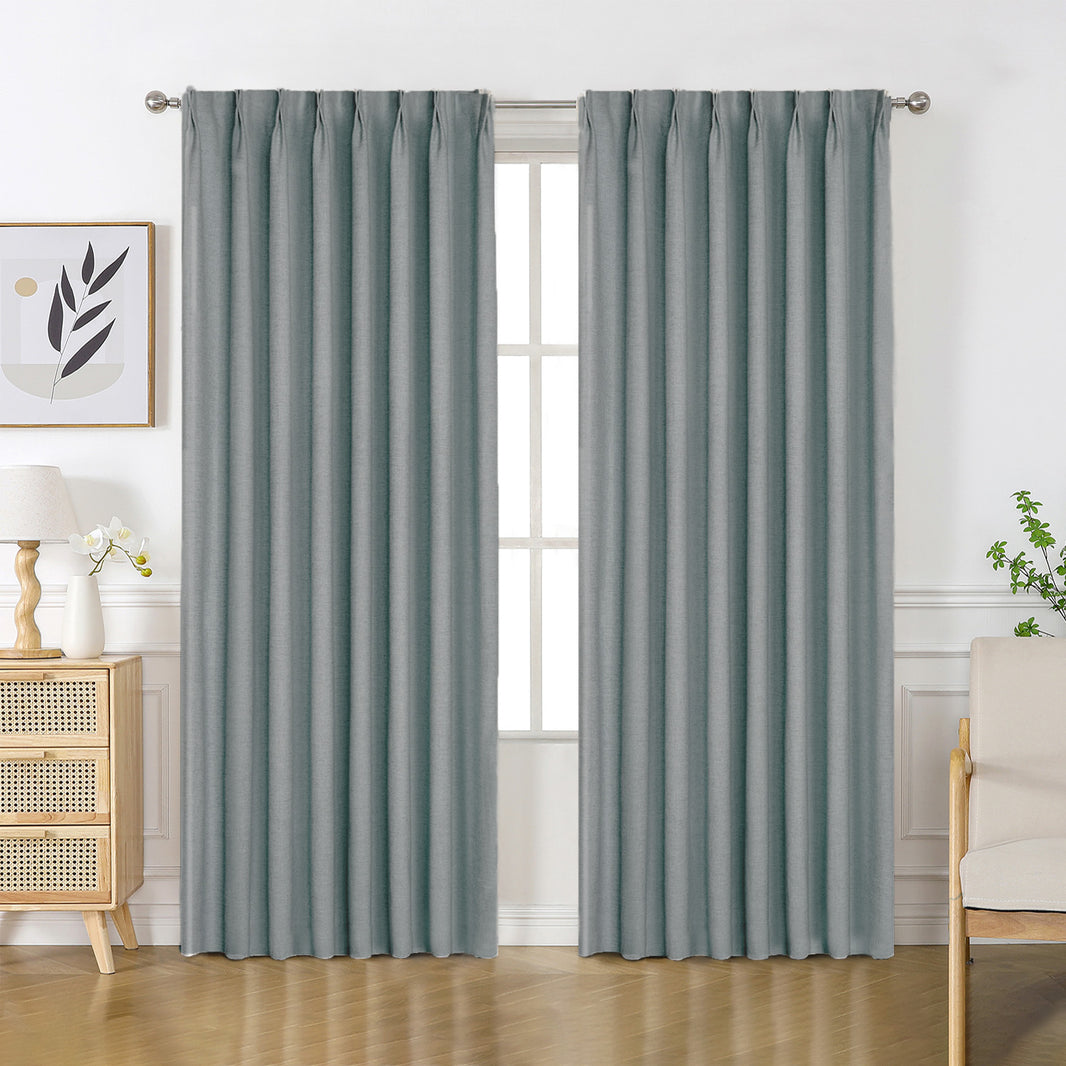 Blue-grey Flaxaline linen blackout curtains with subtle texture, pleated and draped in a modern room. Product display.