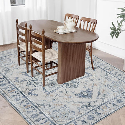 Joydeco blue and grey vintage floral area rug under dining table with chairs on light wood floor.