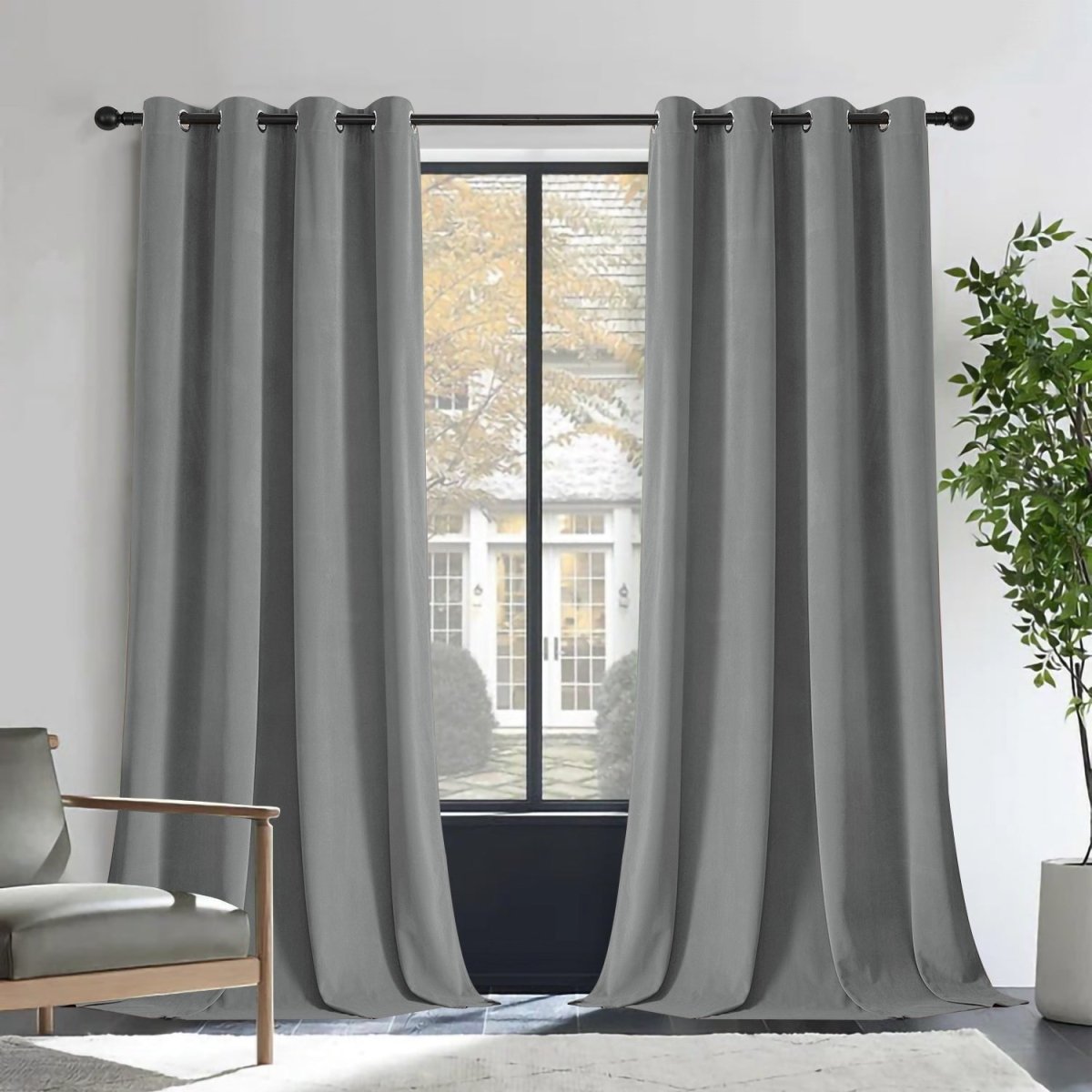 Joydeco Royal Blue velvet blackout curtains on a rod, framing a window with a house view. Thermal insulated for privacy.