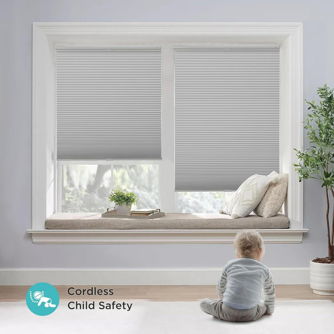 Light gray cordless blackout honeycomb shades, no-drill, with toddler present, highlighting child safety.