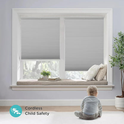 Light gray cordless blackout honeycomb shades, no-drill, with toddler present, highlighting child safety.