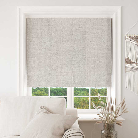 Joydeco custom light beige blackout Roman shade in a living room window, offering stylish light control.