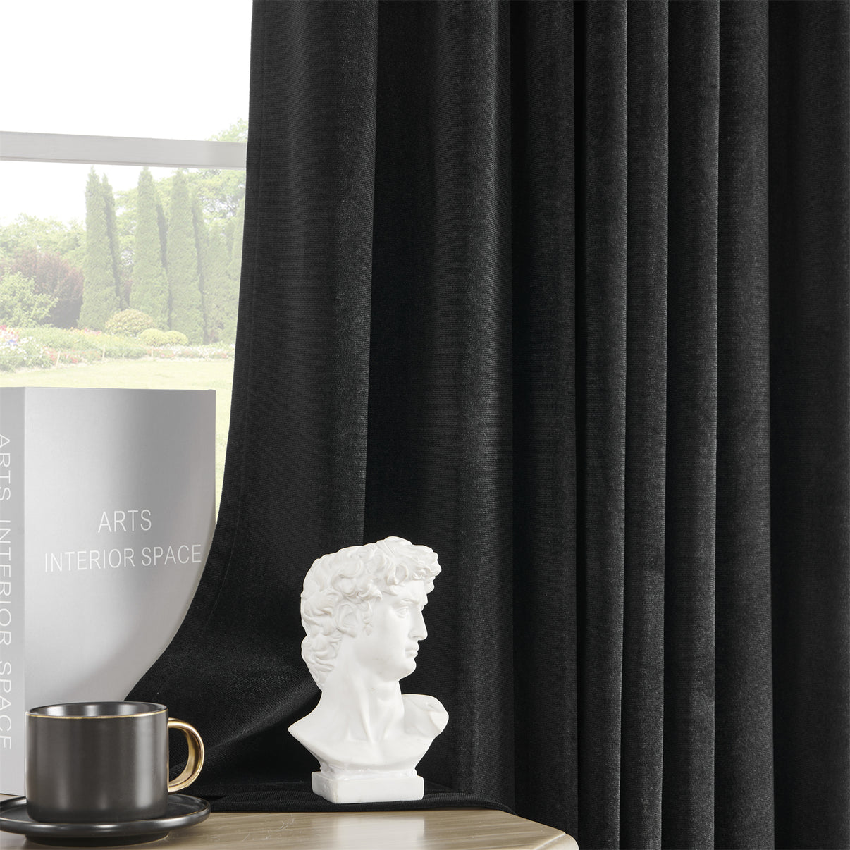 Joydeco black velvet blackout curtains, 84 inch length, plush texture, luxury sheen, in a styled room with decor.
