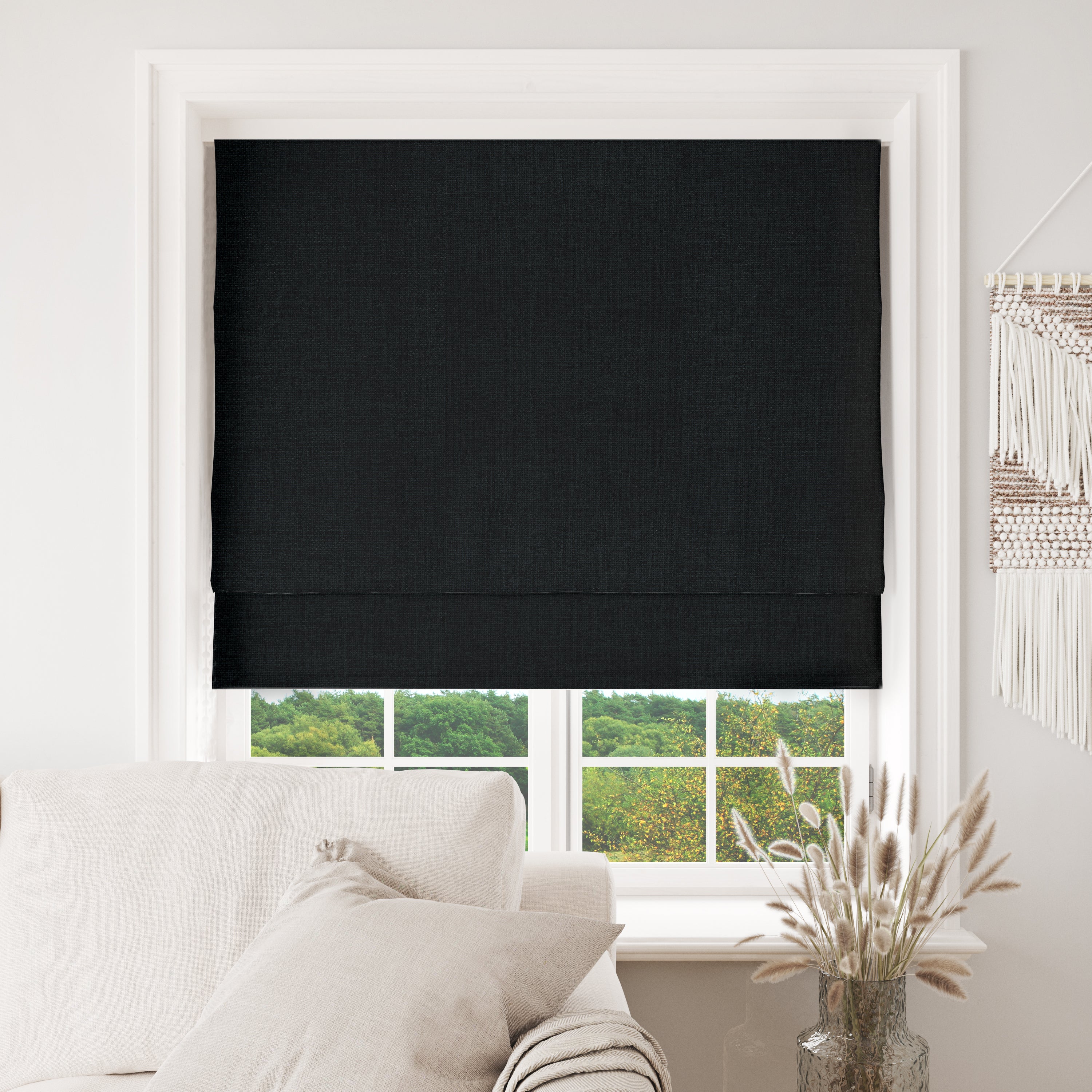 Black Joydeco custom blackout Roman shades installed in a window, showcasing textured fabric and complete light blocking.
