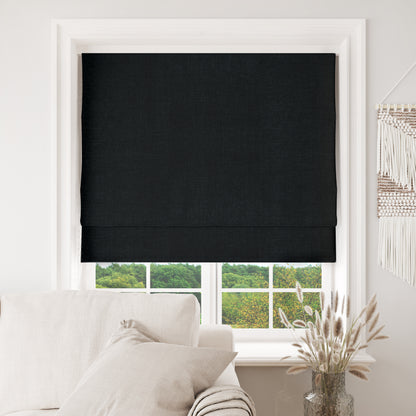 Black Joydeco custom blackout Roman shades installed in a window, showcasing textured fabric and complete light blocking.