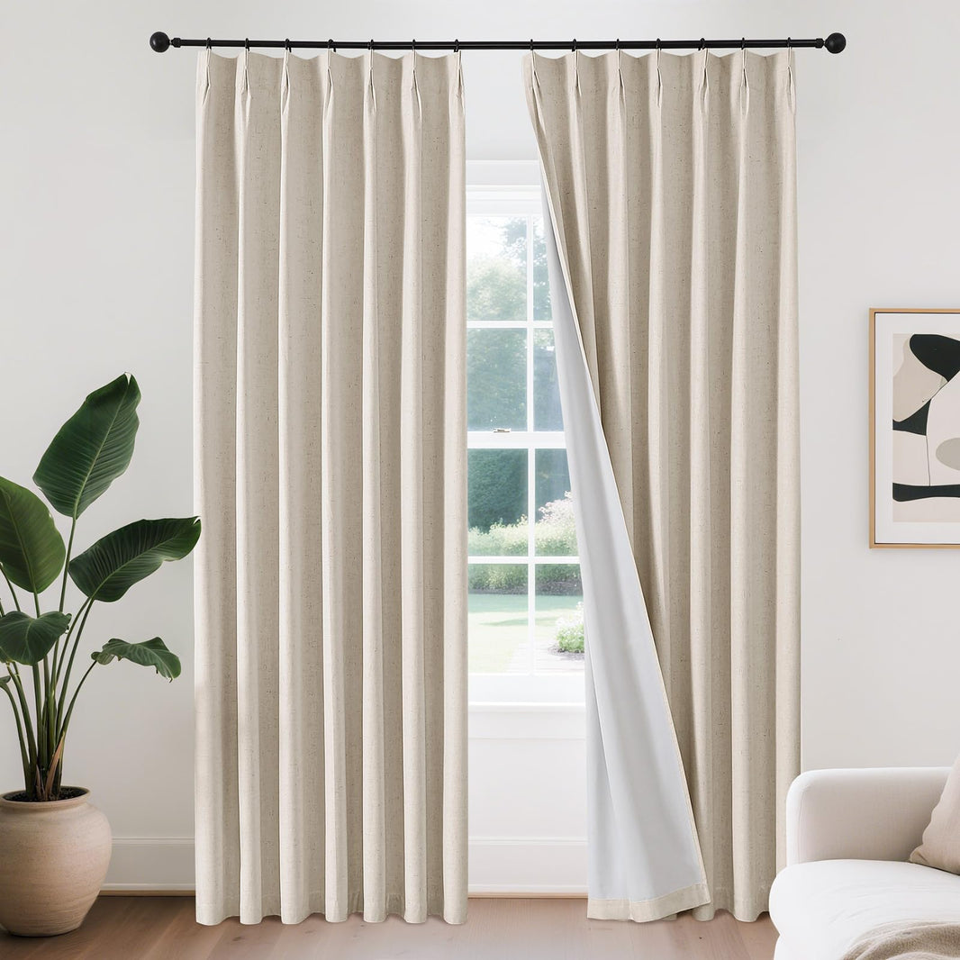Joydeco beige linen blend pinch pleat blackout curtains with white lining on black rod. One panel pulled back.