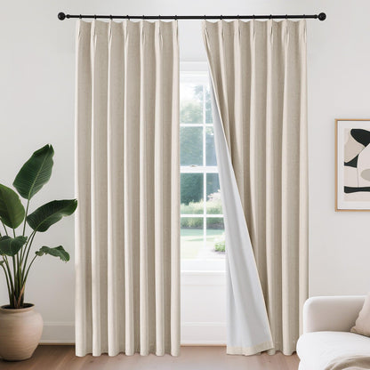 Joydeco beige linen blend pinch pleat blackout curtains with white lining on black rod. One panel pulled back.