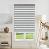 Motorized gray & white striped dual shade controlled by remote, adjustable light filtering & privacy.
