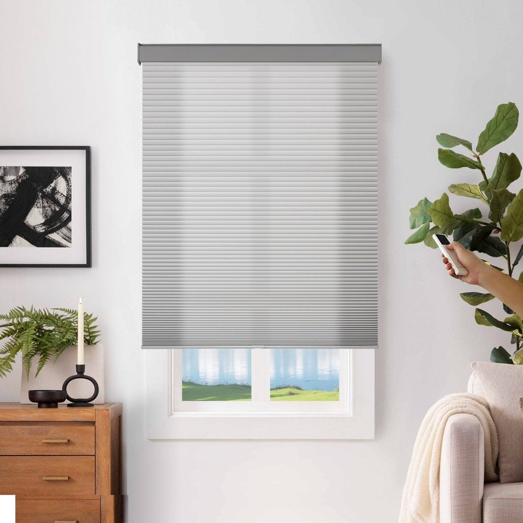 Joydeco light gray cordless motorized blackout cellular shades, operated by remote control in a modern room.