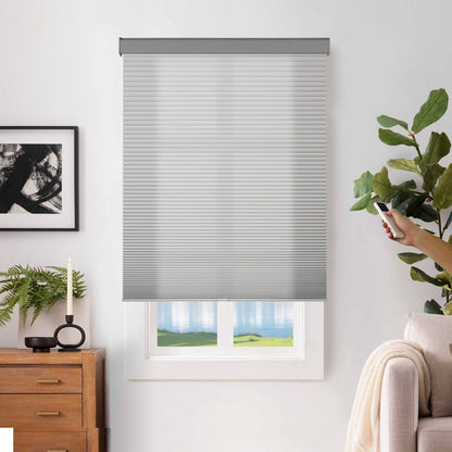 Joydeco light gray cordless motorized blackout cellular shades, operated by remote control in a modern room.
