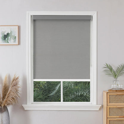 Joydeco custom grey modern blackout roller shade partially lowered in white window frame with woven texture.