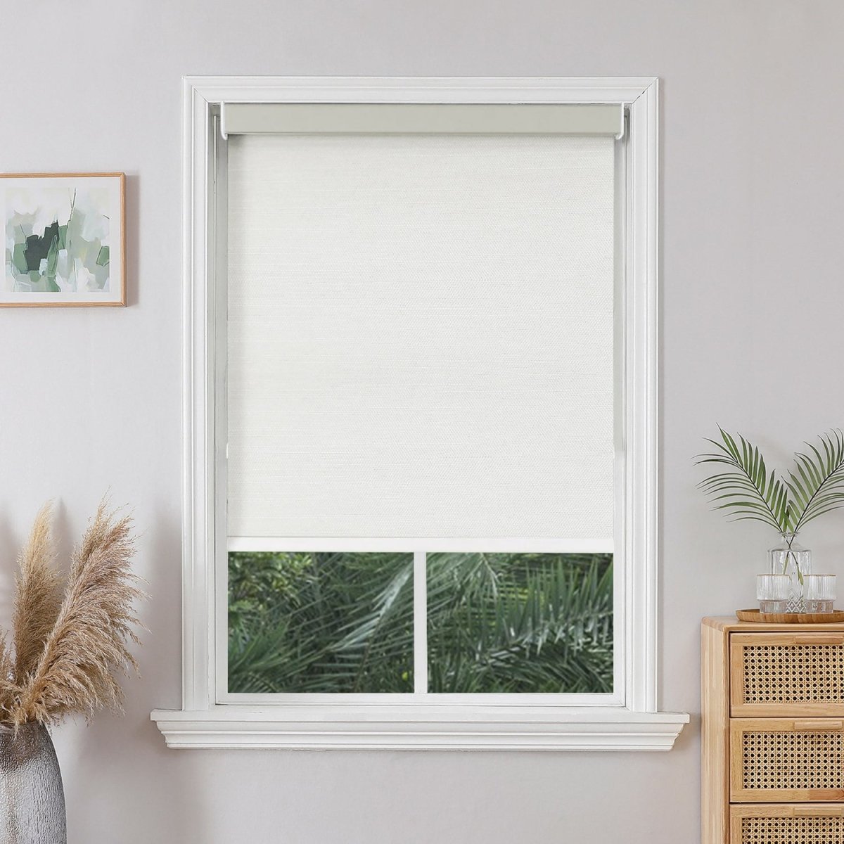 Joydeco custom white blackout roller shade in a white window frame, enhancing a modern room aesthetic.