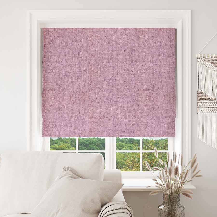 Pink Joydeco textured blackout Roman shade in a white window frame, showcasing complete light control in a room setting.