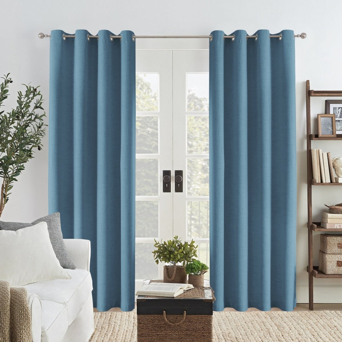 Light blue Joydeco linen blackout curtains with grommets in a living room setting.