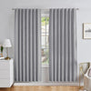 Grey linen blackout curtains with back tab rod pocket style in a modern bedroom, showing pleated drape and texture.