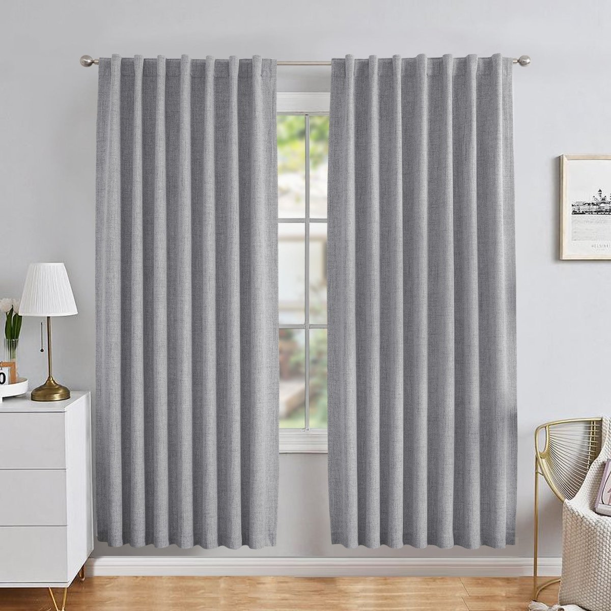 Grey linen blackout curtains with back tab rod pocket style in a modern bedroom, showing pleated drape and texture.