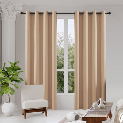 Joydeco beige blackout curtains, two thermal insulated panels hanging in a room with armchair and coffee table.