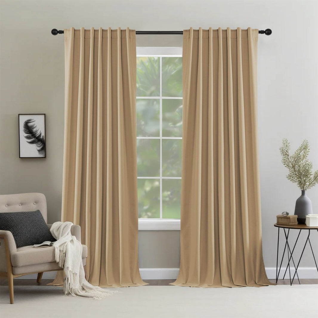 Two dark beige Joydeco thermal insulated blackout curtain panels hanging from a grommet rod in a modern living room.