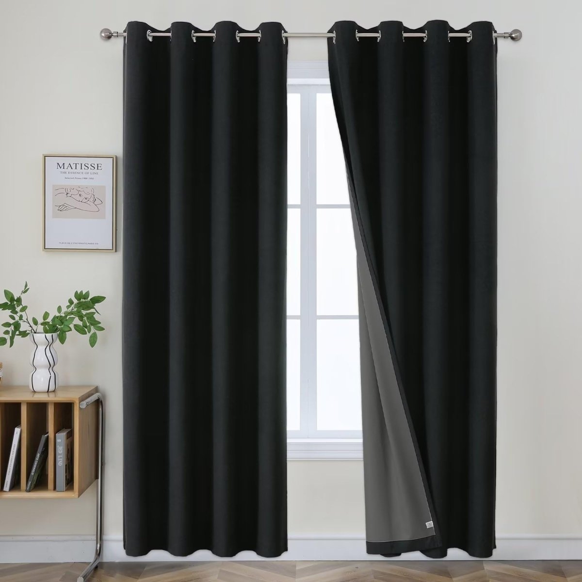 Joydeco two black textured linen blend blackout curtains with grey lining, hanging on a silver rod.