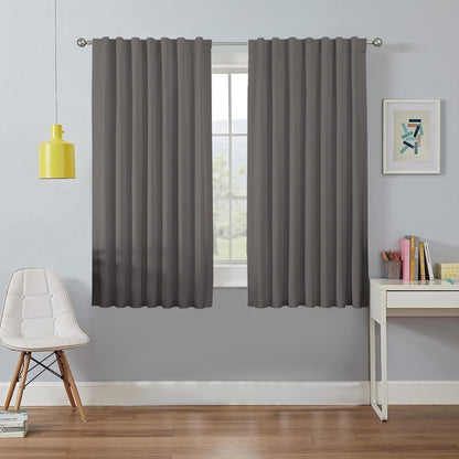 Two grey 100% blackout curtains hang on a silver rod, ideal for bedroom or living room light blocking and privacy.