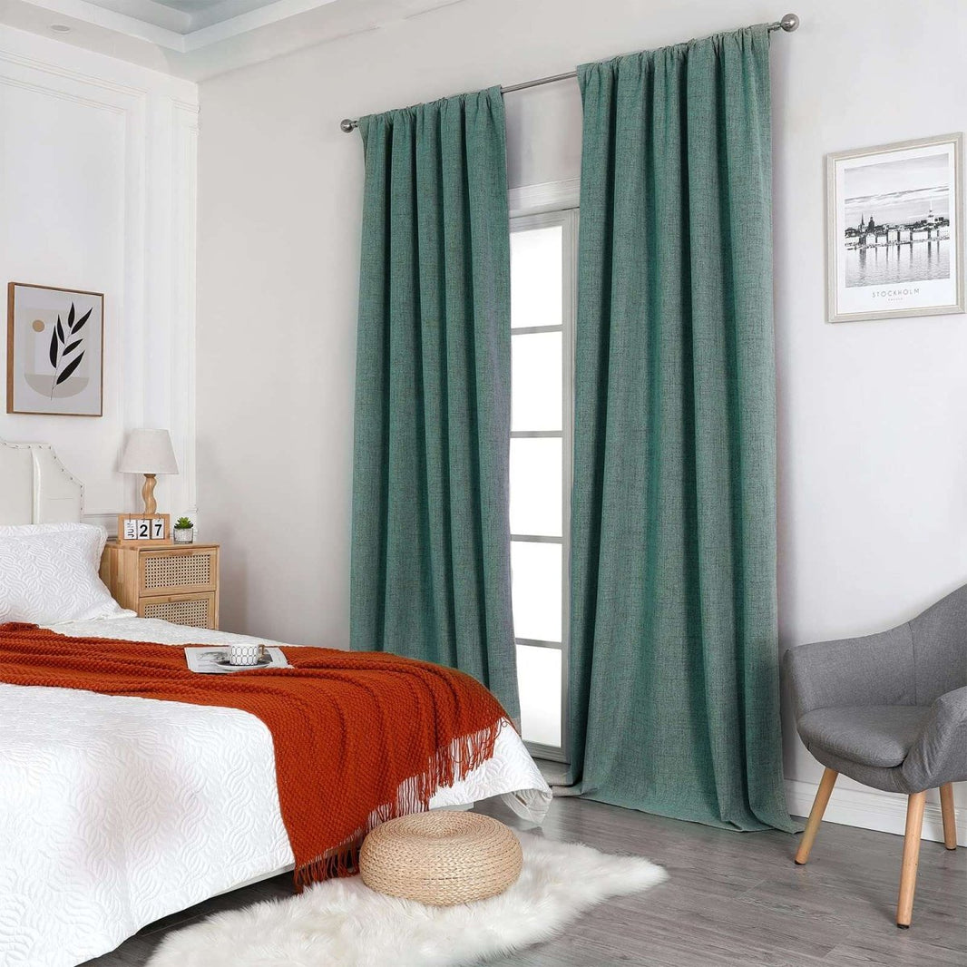 Hunter green linen blackout curtains with thermal insulation shown in a bedroom on a silver rod.
