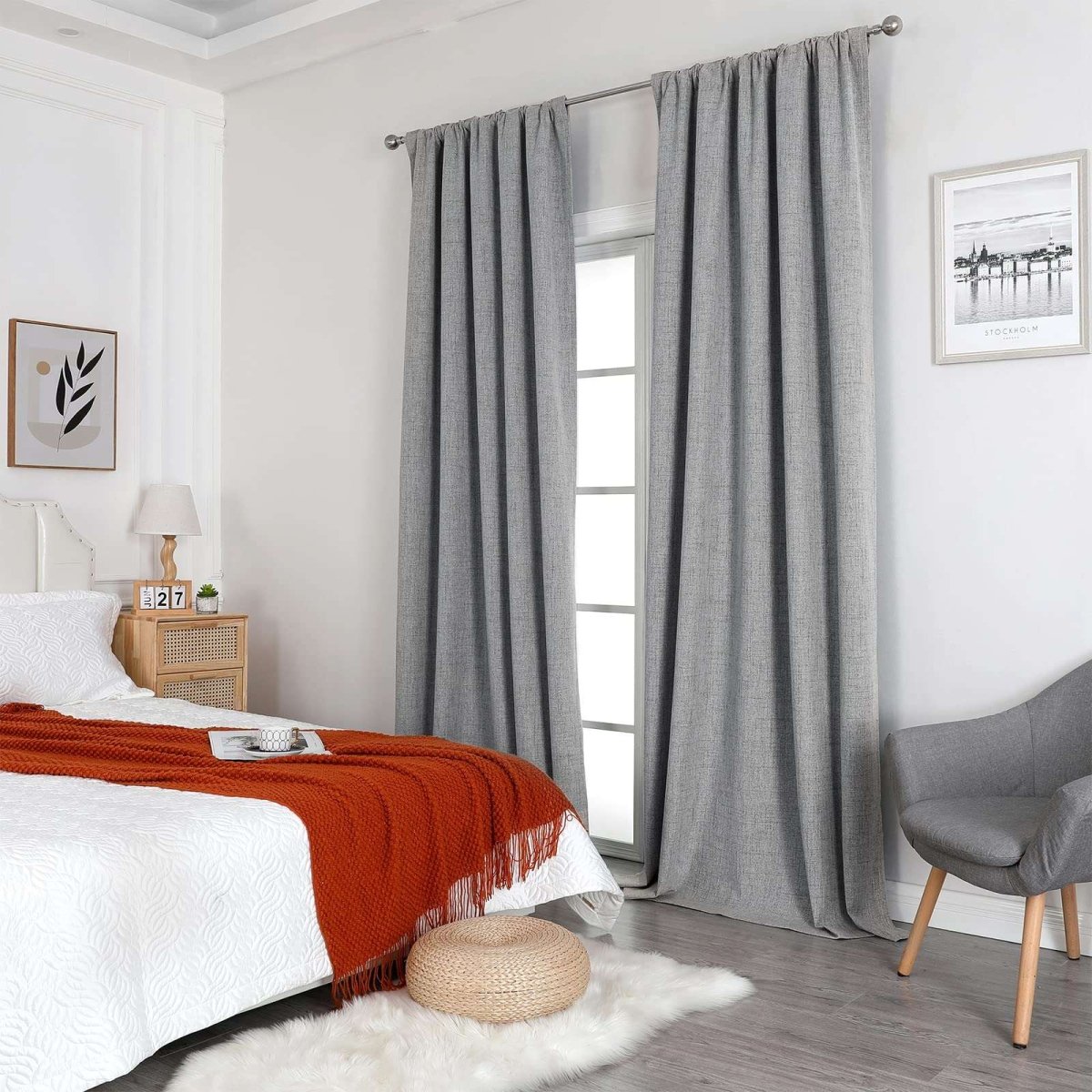 Joydeco light grey linen blackout curtains in a bedroom with a white bed and orange blanket.